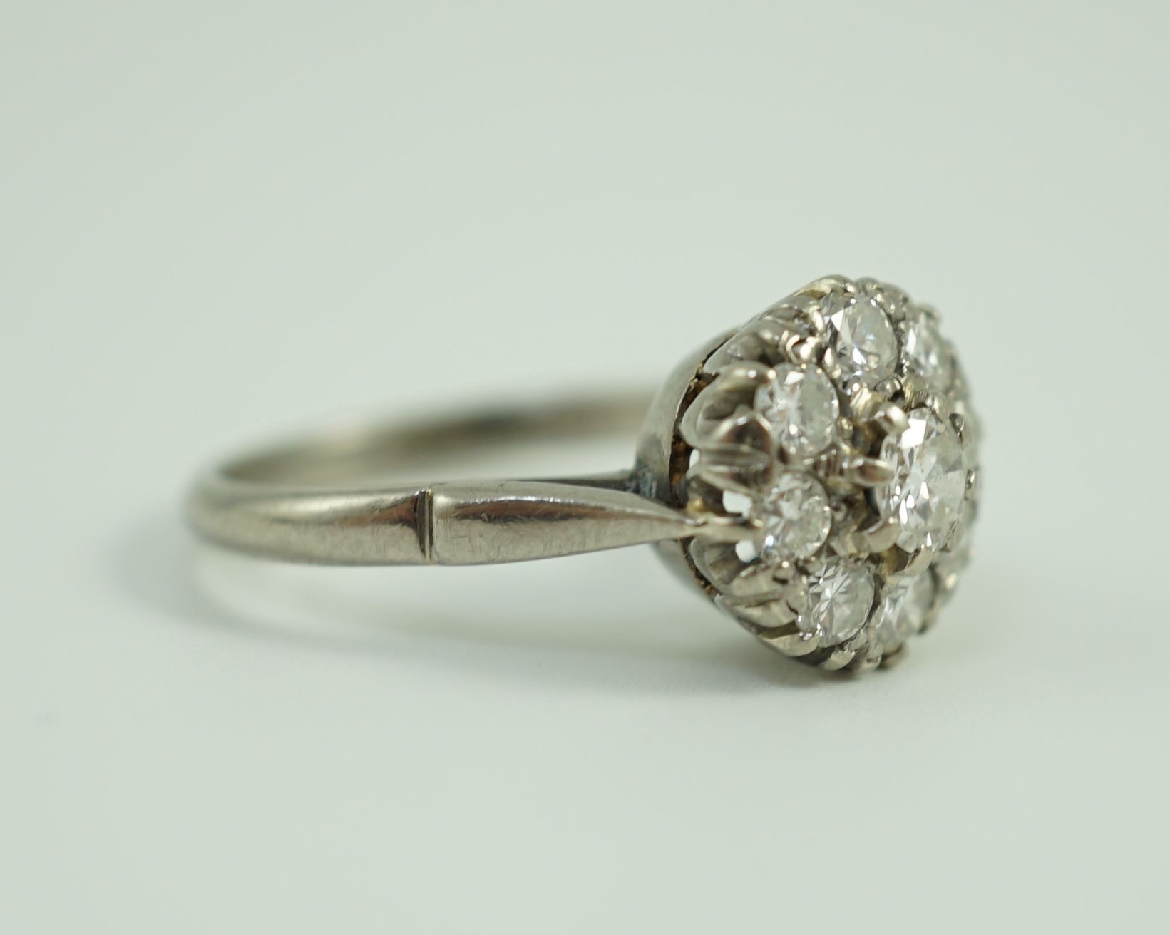 An 18ct white gold and nine stone diamond flower head cluster ring